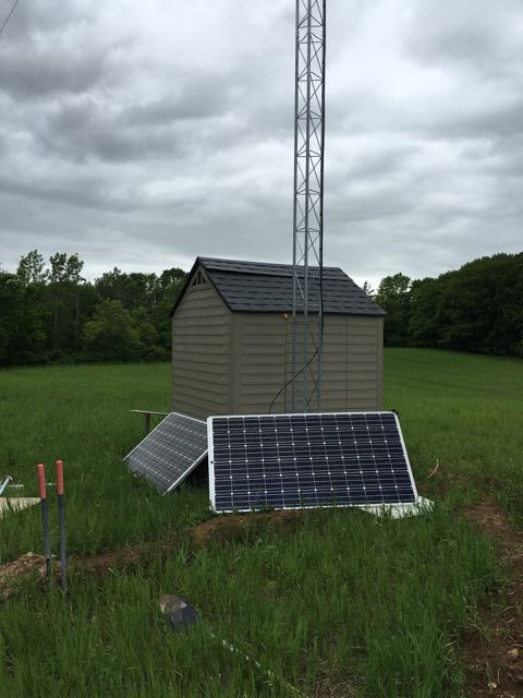 The solar panels temporarily leaning against shed.
